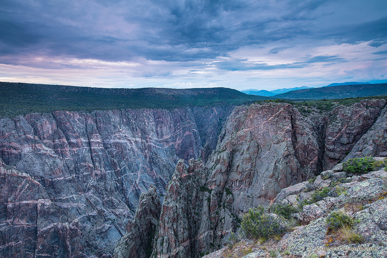 Dusk descends on the Black Canyon of the Gunnison.  The cool blue hues began to prevail throughout the sky and are reflected in the canyon walls. - Colorado Picture