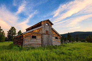 A beautiful wooden barn sits in the Kawuneeche Valley on the western side of Rocky Mountain National Park in Colorado.  Clouds lazily floated by as the sun set behind the Never Summer Range in the distance. - Colorado Landscape Photograph