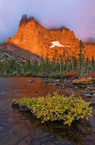 One of my favorite lakes in Rocky Mountain is Lake Helene.  About 2 and a half miles from Bear Lake, this spot is nestled at the bottom of Notchtop Mountain.  On a September day, the leaves on the bushes have turned a bright crimson hue and the early morning fog begins to dissipate quickly as the the mountain glows with the advent of a new dawn.  It is serenity and peacefulness with only the rustling of the trees and the occasional chirp of a Stellers Jay. - Colorado Photograph