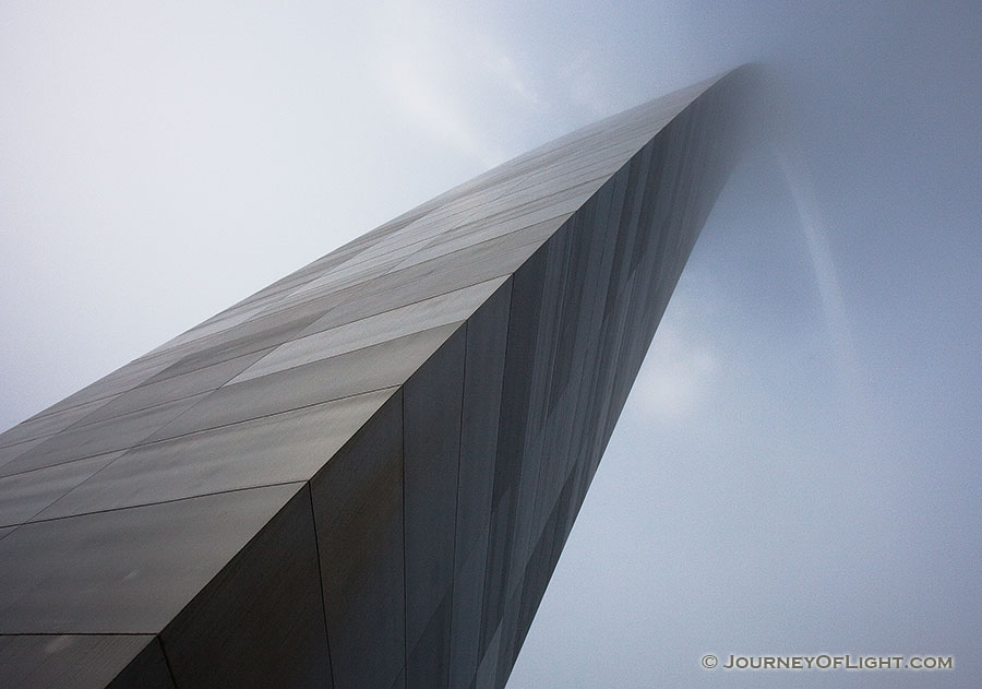 From the base of the north leg looking in a south easterly directly, the Gateway Arch curves through the sky and into the fog.  - Jefferson National Expansion Memorial Photography