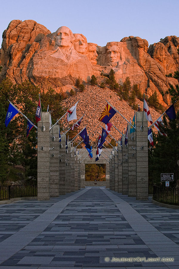 Mt. Rushmore National Monument at sunrise with the Avenue of Flags in the Black Hills of South Dakota. - Mt. Rushmore NM Photography