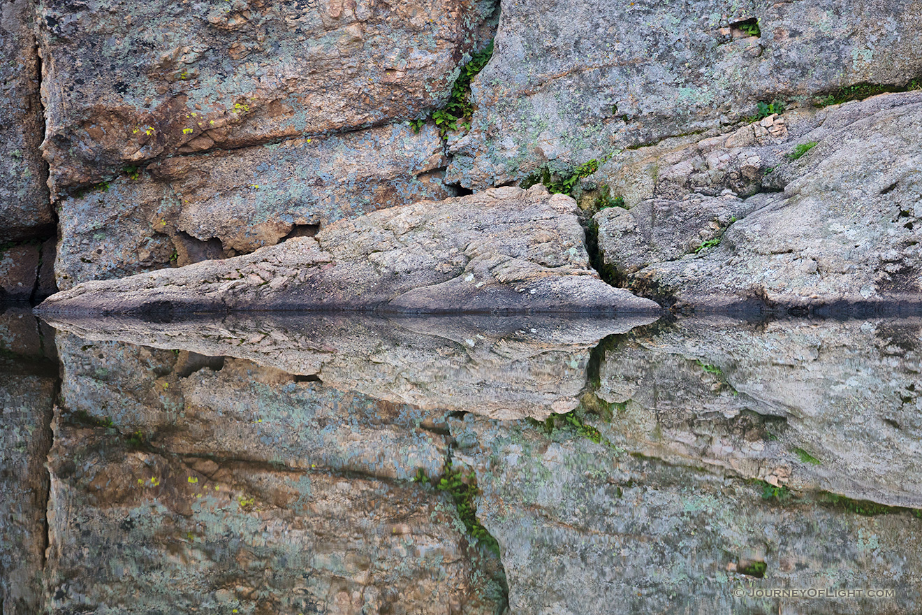 An abstract photograph of rocks reflected in Sylvan Lake in Custer State Park, South Dakota. - South Dakota Picture