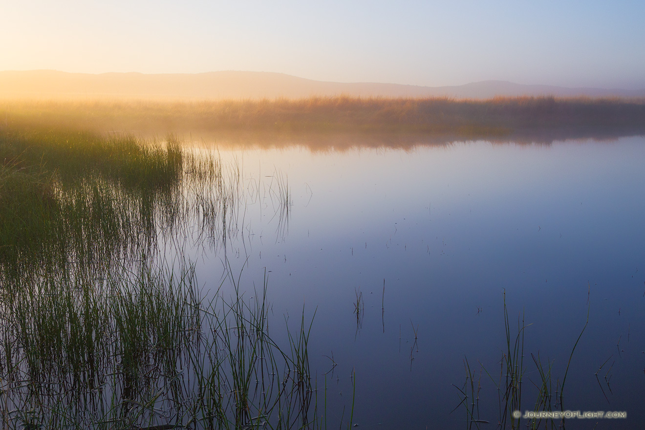 The glow of the morning sun illuminates a small pond in Crescent Lake National Wildlife Refuge in western Nebraska. - Nebraska Picture