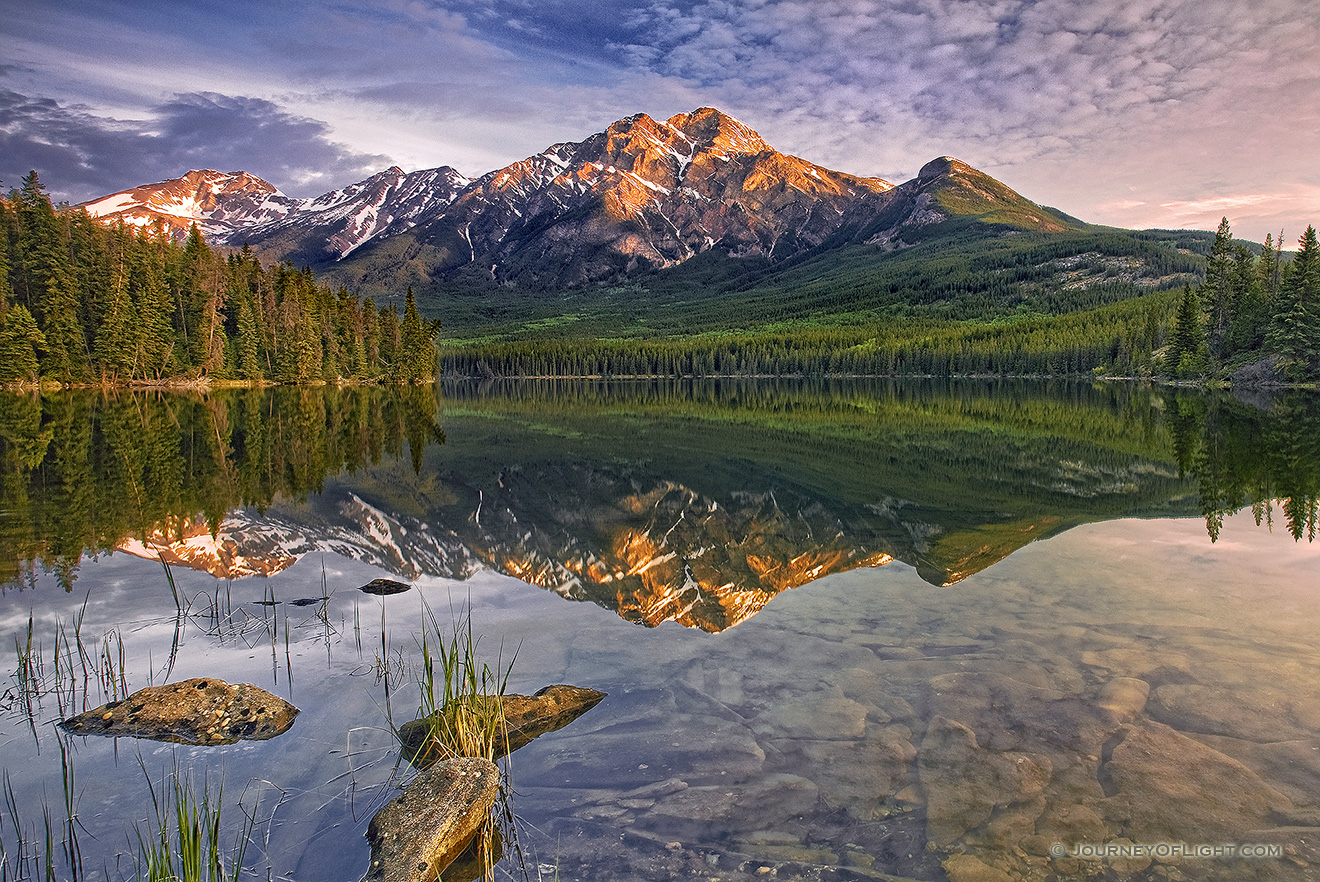 Morning light bathes Pyramid mountain in Jasper National Park.The scene is nearly perfect reflected in the still waters of Pyramid Lake. - Jasper Picture